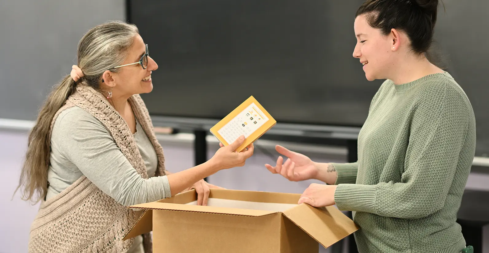 Une enseignante donne une calculatrice NumWorks a son élève